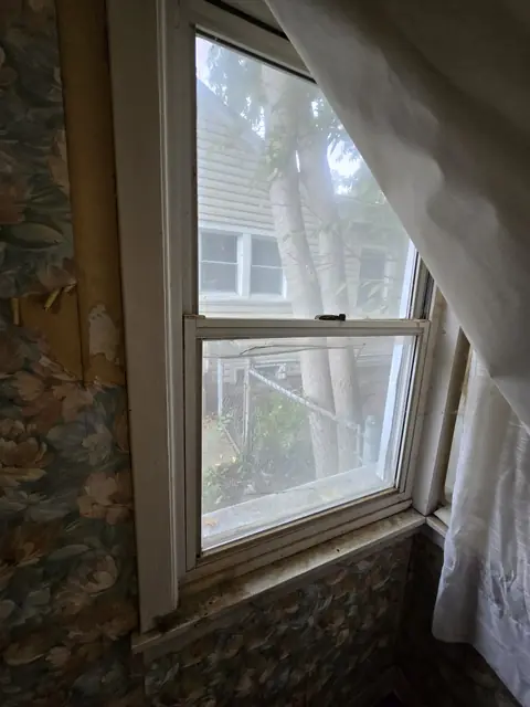 Window with wallpaper peeling around the frame