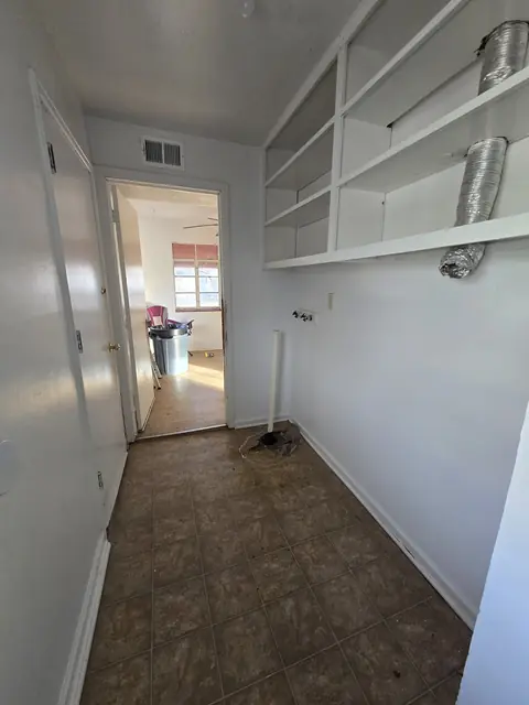 Laundry area with a hole in the floor by the drain pipe