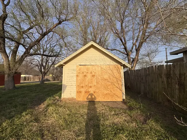Detached garage with plywood nailed over the door