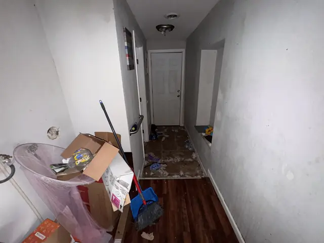 Hallway with boxes and trash by the back door