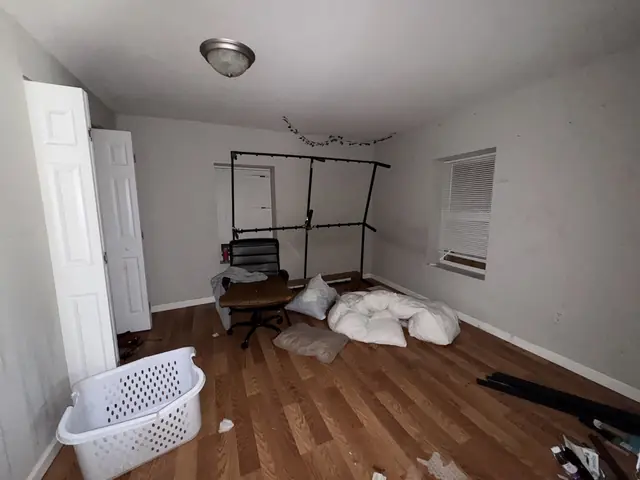 Bedroom with a broken bed frame and junk on the floor