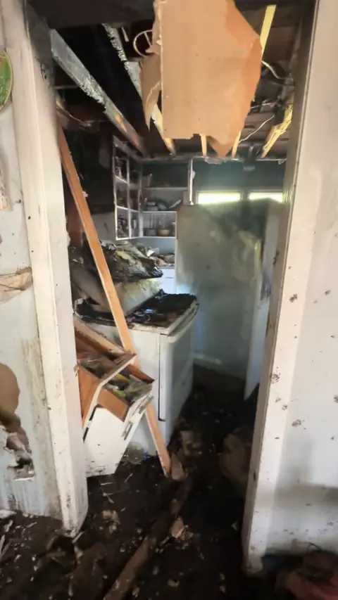 Kitchen from the hallway, with ceiling boards hanging down