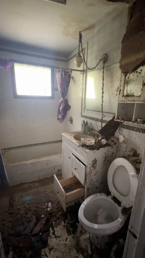Bathroom with fallen ceiling material and soot